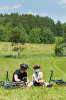 Sport mountain biking couple relax in meadows