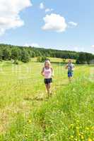 Sportive young couple jogging meadows sunny summer