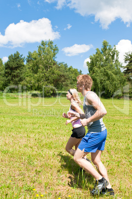 Sportive young couple jogging meadows sunny summer