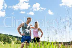 Sportive happy couple in meadows sunny day