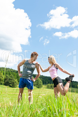 Sportive happy couple in meadows sunny day
