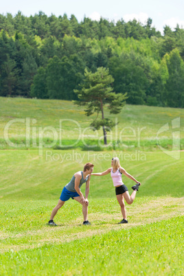 Sportive jogging couple stretching in countryside