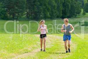 Sportive young couple jogging meadows sunny summer