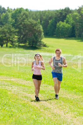 Sportive young couple jogging meadows sunny summer