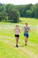 Sportive young couple jogging meadows sunny summer