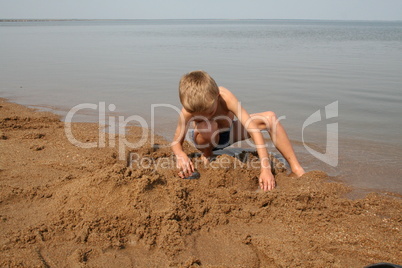Junge spielt im Sand