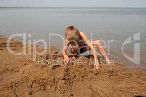 Junge spielt im Sand