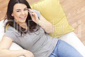 Happy Hispanic Woman Using Cell Phone At Home