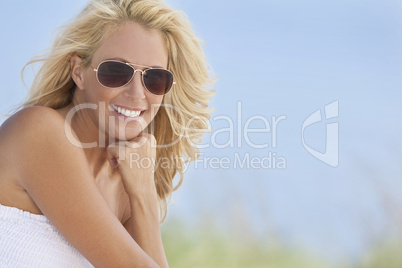 Beautiful Blond Woman in White Dress and Sunglasses At Beach