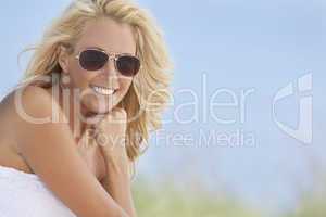 Beautiful Blond Woman in White Dress and Sunglasses At Beach