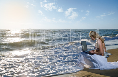 blond girl using laptop on  sea