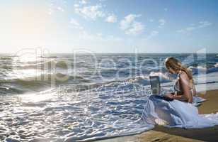 blond girl using laptop on  sea