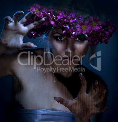beauty woman portrait with wreath from flowers on head over blue background