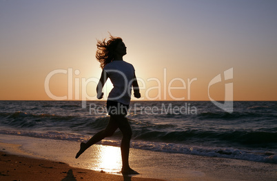 silhouette girl run on sea coast