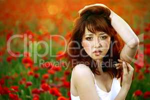 woman closeup portrait in poppy field