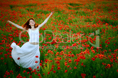 woman in white dress running poppy field