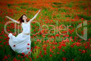 woman in white dress running poppy field