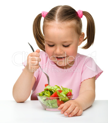 Cute little girl eats vegetable salad