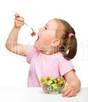 Cute little girl eats vegetable salad
