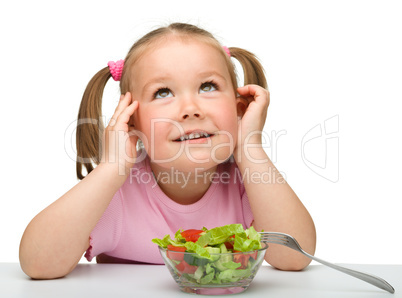 Cute little girl eats vegetable salad