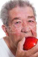 Senior isst einen Apfel