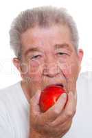 Senior beisst genüsslich in einen Apfel