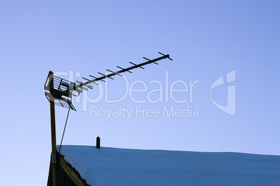 Television antenna over the snowy roof