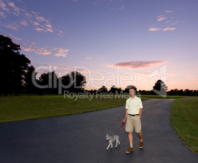 Senior man walking dog at sunset