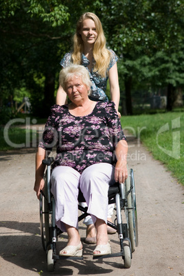 Seniorin im Rollstuhl mit ihrer Großtochter