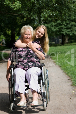 Seniorin im Rollstuhl mit ihrer Großtochter