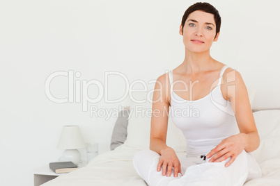 Close up of a woman sitting on her bed