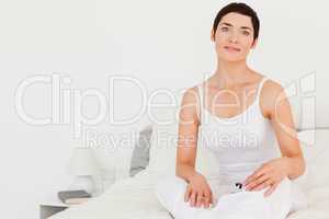 Close up of a woman sitting on her bed