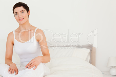 Close up of a young woman sitting on her bed