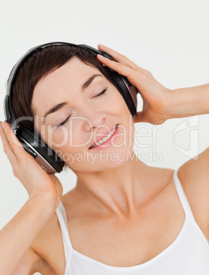 Portrait of a charming brunette listening to music