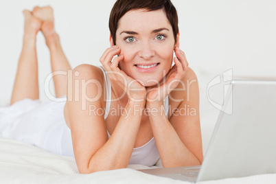 Close up of a woman posing with a laptop