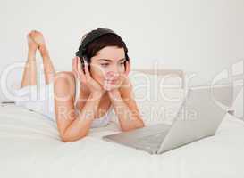 Young woman listening to music with her laptop