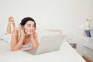 Young woman watching a movie with her laptop