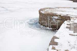 Stone pier on the frozen reservoir