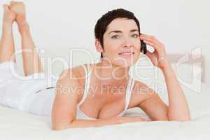 Woman calling while lying on her bed