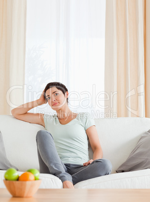 Portrait of a lovely woman sitting on a sofa