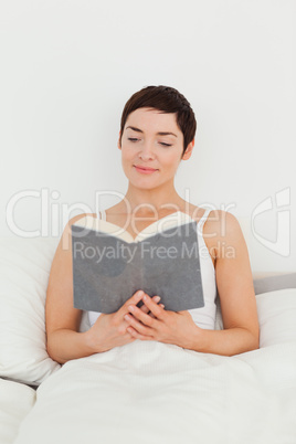 Smiling brunette reading a book