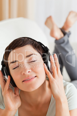 Portrait of a charming brunette listening to music