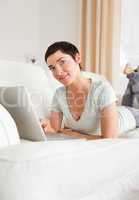 Portrait of a smiling short-haired woman with a laptop