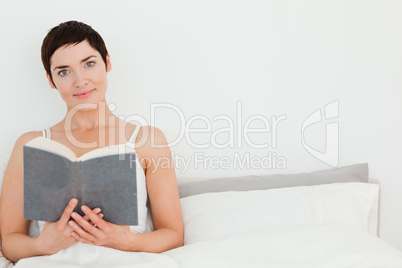 Close up of a brunette holding a book