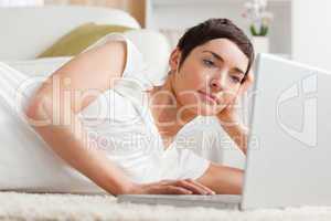 Close up of a serious woman relaxing with a laptop