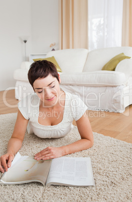 Portrait of a smiling brunette reading a magazine