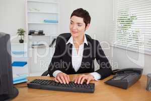 Charming secretary typing on her keybord