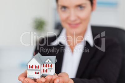 Businesswoman holding a miniature house