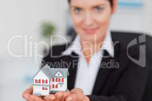 Businesswoman holding a miniature house