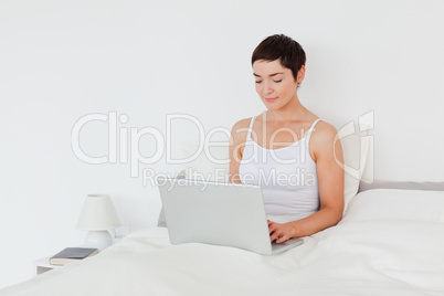 Charming brunette using a laptop